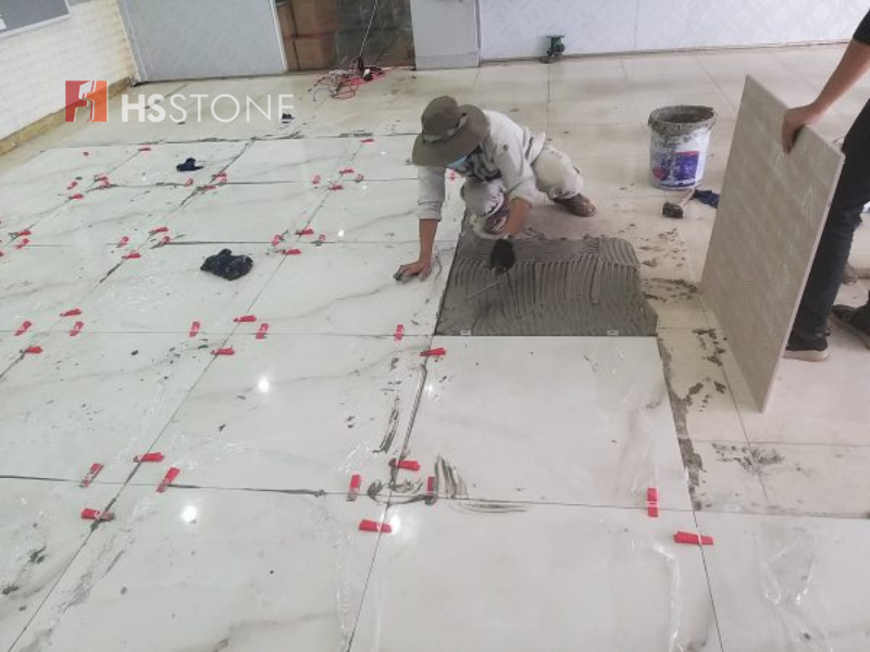 Cần trải đều keo dán chuyên dụng lên bề mặt sàn và lưng gạch